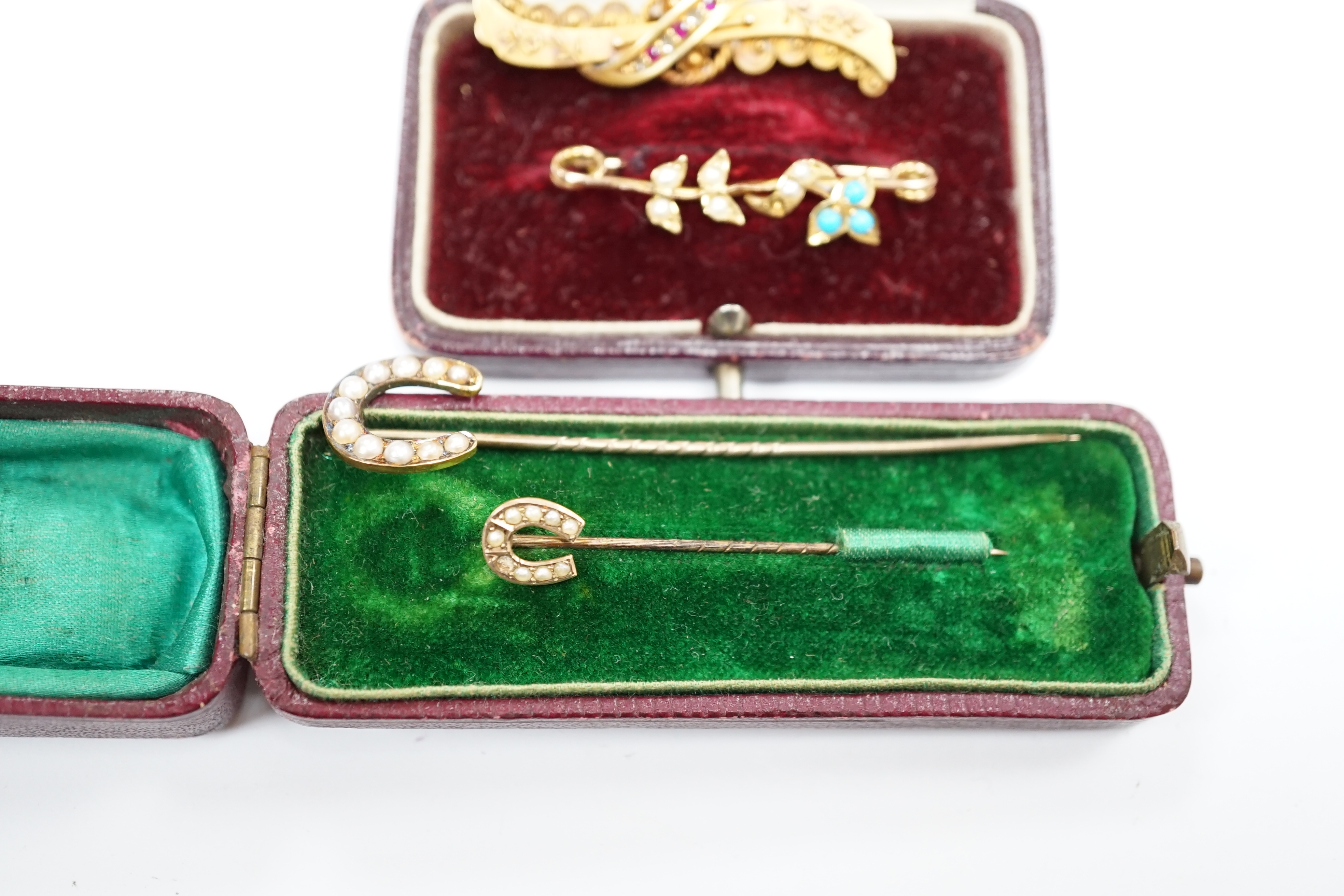 A late Victorian 15ct gold, ruby and diamond chip set bar brooch, 39mm, a yellow metal, seed pearl and turquoise set bar brooch and two seed pearl set horseshoe stick pins, one stamped 9ct, the other 18. Condition - fair